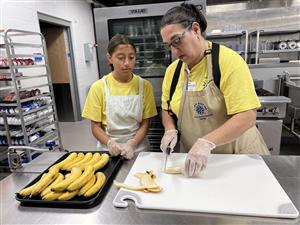 student learning to cut bananas