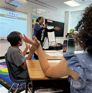 Teacher clapping with students