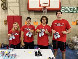 Churchill students holding up shoes